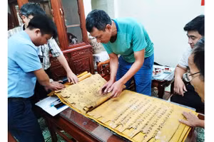Nhà sưu tập Đặng Vũ Khương cùng đại diện người dân Tri Chỉ kiểm tra tình trạng sắc phong. Ảnh: NCVV