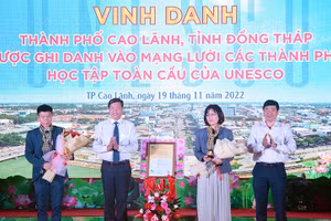 Bà Miki Nozawa, Trưởng Ban Giáo dục Văn phòng UNESCO tại Hà Nội trao chứng nhận cho thành phố Cao Lãnh và nhận biểu trưng, hoa do tỉnh Đồng Tháp trao tặng.