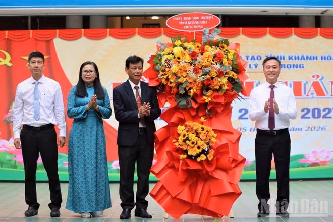 Chủ tịch Ủy ban nhân dân tỉnh Nguyễn Việt Hùng tặng hoa chúc mừng Trường trung học phổ thông Lý Tự Trọng nhân ngày khai giảng năm học mới. (Ảnh: VŨ TÂN)