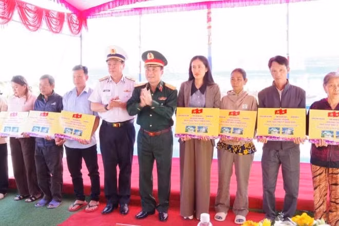Thiếu tướng Trần Minh Trọng, Phó Chính ủy Quân khu 5 và Chuẩn Đô đốc Phạm Minh Tuấn, Phó Tư lệnh Quân chủng Hải quân trao bảng tượng trưng bàn giao nhà cho 10 gia đình bị thiệt hại do mưa lũ tại Khánh Hòa.