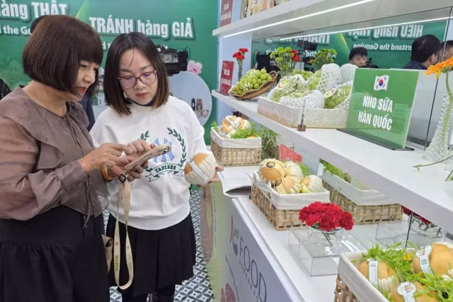 Chuyên viên của Cục Quản lý và Phát triển thị trường trong nước hướng dẫn khách tham quan nhận diện sản phẩm quả lê Hàn Quốc.