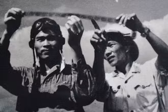 Phi công Nguyễn Văn Bảy (trái) cùng đồng đội xem lại những tấm phim do máy ảnh tự động chụp khi điểm hỏa. (Ảnh tư liệu)