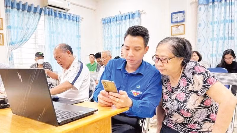 Đoàn viên phường Tây Hồ hướng dẫn người dân các thao tác thực hiện thủ tục hành chính trên điện thoại di động.