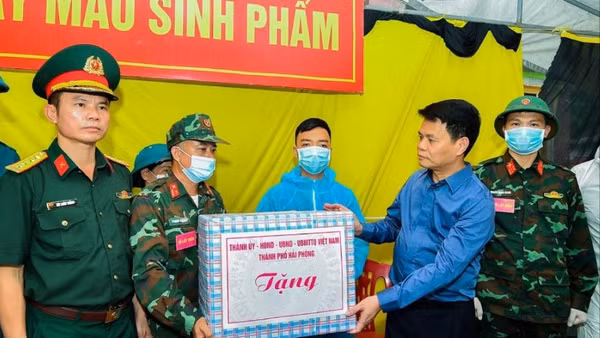 Đồng chí Lê Ngọc Châu tặng quà, động viên lực lượng thực hiện nhiệm vụ lấy mẫu ADN hài cốt liệt sĩ. (Ảnh: THÀNH CHUNG)