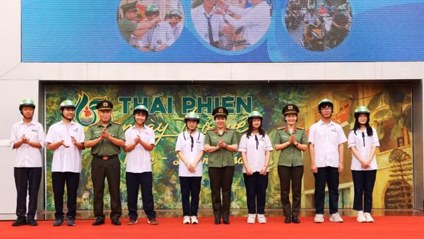 Ban tổ chức chương trình tặng mũ bảo hiểm cho các em học sinh Trường trung học phổ thông Thái Phiên.