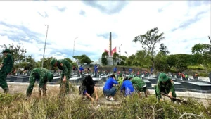 Cán bộ, chiến sĩ của Đồn Biên phòng An Hải và đoàn viên, thanh niên địa phương tham gia dọn dẹp, chỉnh trang khuôn viên nghĩa trang liệt sĩ.