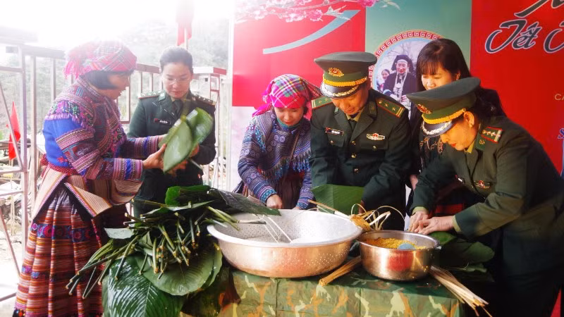 Cán bộ, chiến sĩ Bộ đội Biên phòng và nhân dân tham gia gói bánh chưng đón Tết.