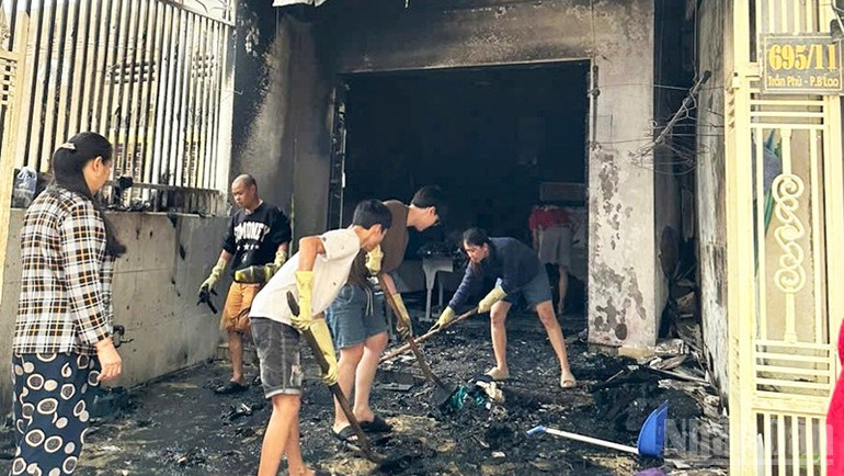Các lực lượng cùng người dân hỗ trợ gia đình dọn dẹp khắc phục hậu quả sau vụ hỏa hoạn. ndo_br_xc.jpg