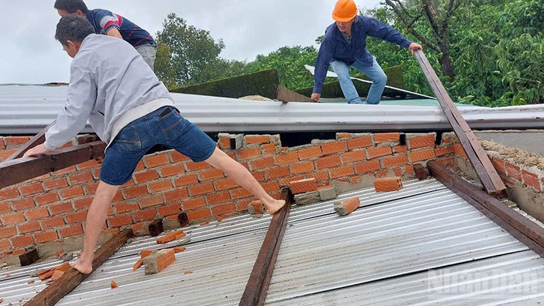 Các lực lượng hỗ trợ một hộ dân trên địa bàn Phường 2 Bảo Lộc lợp lại mái nhà bị tốc. ndo_br_nn.jpg