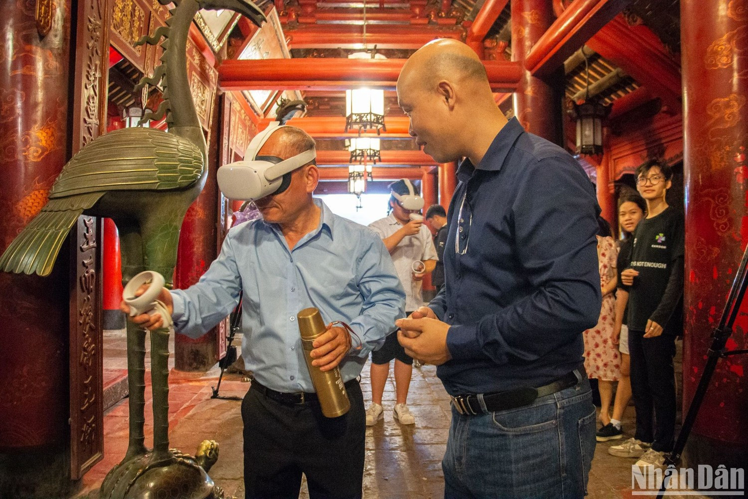 Khách du lịch trải nghiệm hệ thống thực tế ảo tại di tích Văn Miếu-Quốc Tử Giám. (Ảnh: HÀ NAM)