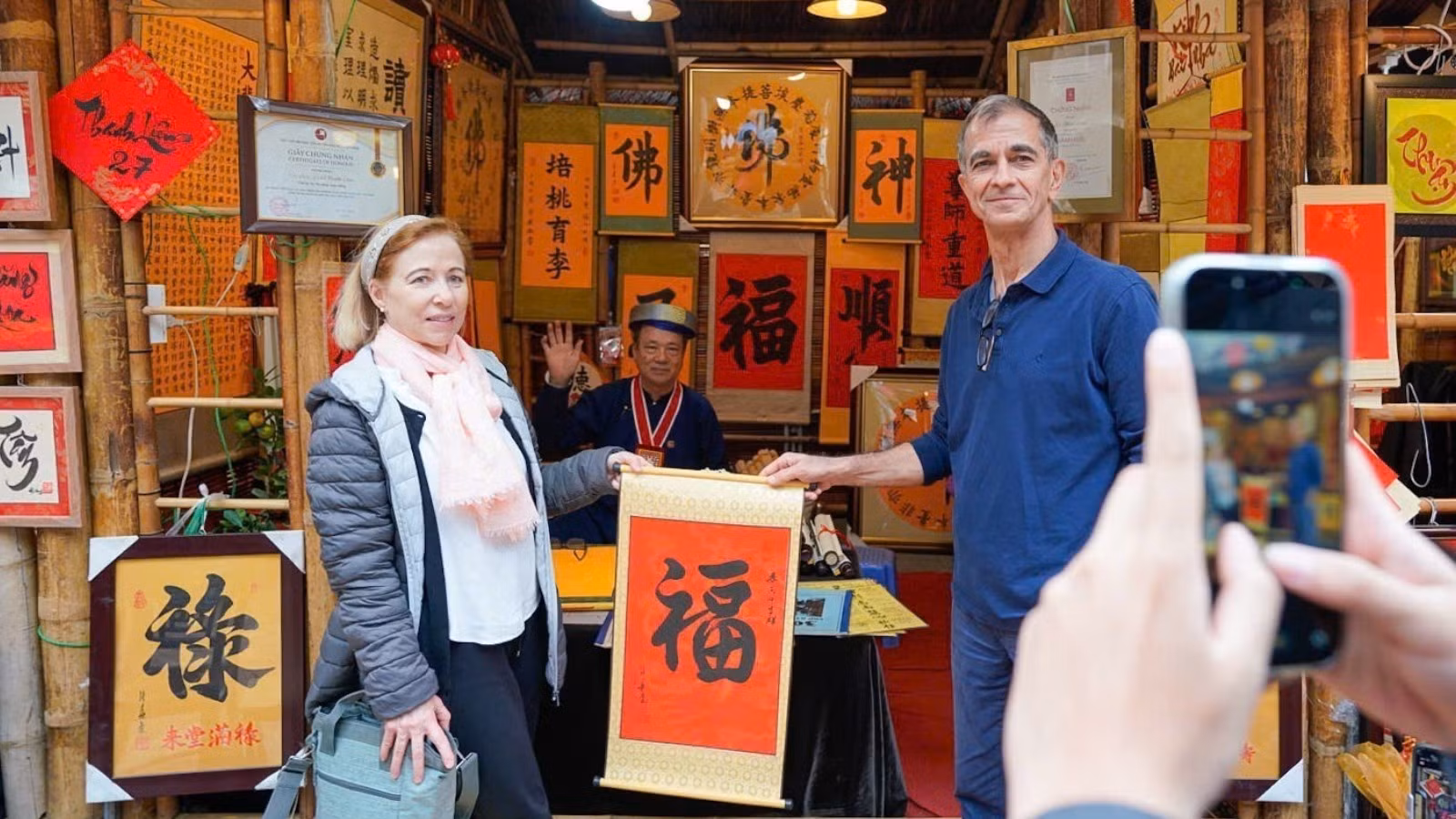 Khách quốc tế trải nghiệm hoạt động xin chữ đầu năm. (Ảnh: TTXVN)