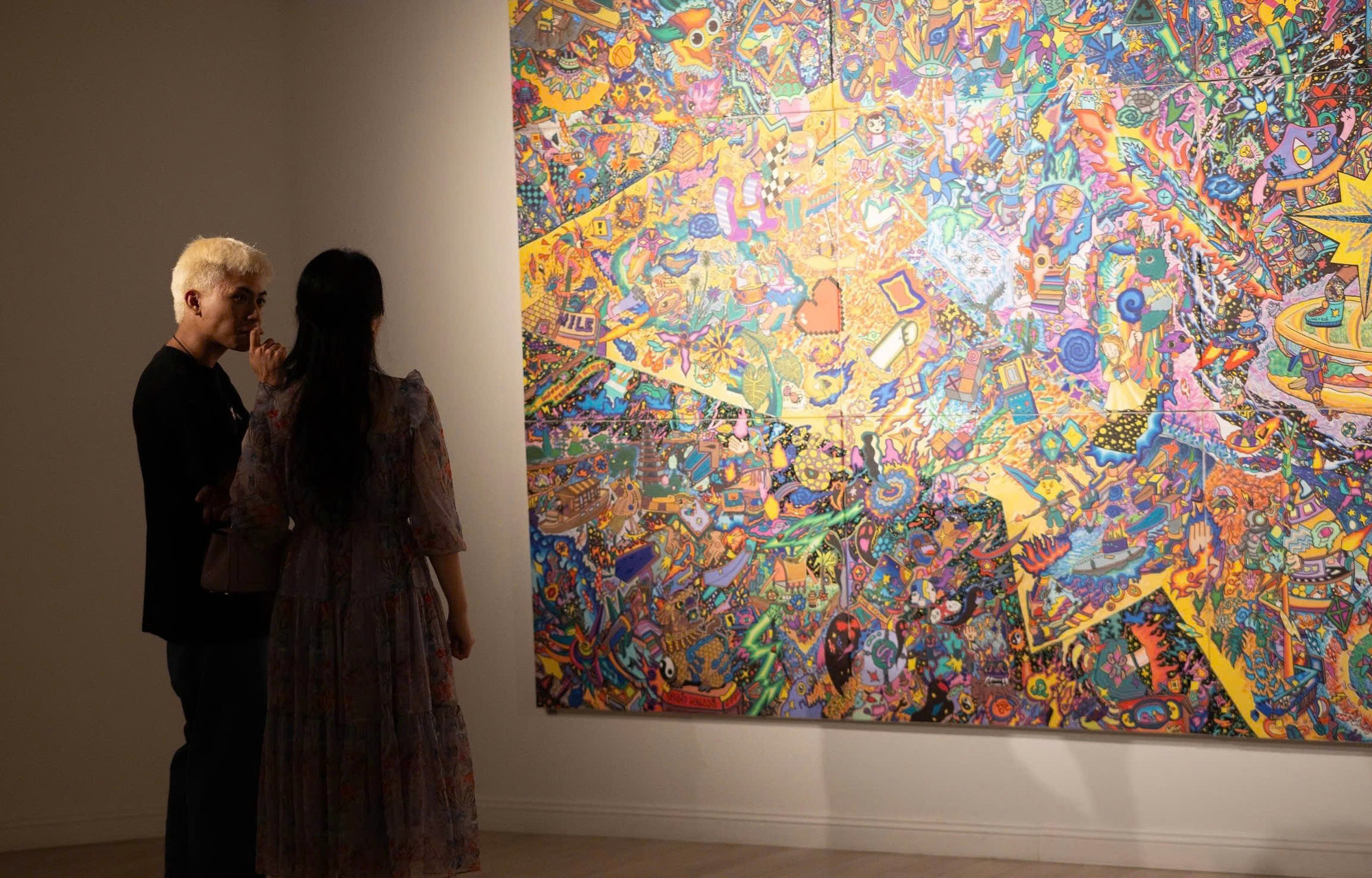 Họa sĩ Hoàng Anh Trung chia sẻ với phóng viên về quá trình sáng tạo. (Ảnh: Mơ Art Space)