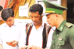 Cán bộ Đồn Biên phòng Tuy Đức hướng dẫn người dân biên giới sử dụng mã QR gửi tin báo qua “Hòm thư điện tử ẩn danh” tố giác tội phạm (Ảnh NGUYỄN NAM)