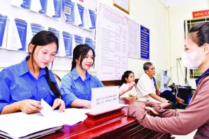 Đoàn viên, thanh niên tình nguyện hỗ trợ người dân xã Minh Châu làm thủ tục hành chính công tại trụ sở xã.