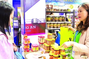 Doanh nghiệp giới thiệu mắm chua, mắm ruốc, muối tôm Chân Ý (Tây Ninh) tại một hội chợ. (Ảnh LAN NGỌC)