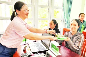 Nhân viên tín dụng Ngân hàng Chính sách xã hội Ninh Phước (Khánh Hòa) giải ngân vốn vay cho người dân đầu tư phát triển kinh tế hộ gia đình.