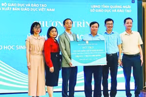 Đại diện Nhà xuất bản Giáo dục Việt Nam trao tặng sách giáo khoa cho học sinh vùng lũ Quảng Ngãi. (Ảnh ÁI KIỀU)