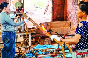 Công nhân Công ty TNHH Ngọc Chung Coir hoàn thiện sản phẩm dây thừng trang trí trước khi xuất xưởng. (Ảnh MỸ HÀ)