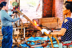 Công nhân Công ty TNHH Ngọc Chung Coir hoàn thiện sản phẩm dây thừng trang trí trước khi xuất xưởng. (Ảnh MỸ HÀ)