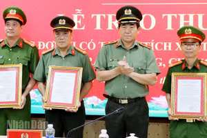 Thiếu tướng Nguyễn Văn Hận, Giám đốc Công an tỉnh An Giang trao quyết định khen thưởng cho các đơn vị. (Ảnh: TẤN AN).
