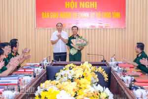 Đồng chí Lâm Minh Thành, Phó Bí thư Thường trực Tỉnh ủy An Giang trao hoa chúc mừng Đại tá Nguyễn Việt Thắng, Phó Bí thư Thường trực Đảng ủy Quân sự, Chính ủy Bộ Chỉ huy quân sự tỉnh An Giang. (Ảnh: PHƯƠNG VŨ)