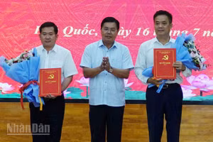 Ủy viên Trung ương Đảng, Bí thư Tỉnh ủy An Giang Nguyễn Tiến Hải trao quyết định và tặng hoa chúc mừng đồng chí Đinh Văn Nơi và đồng chí Lê Quốc Anh. 