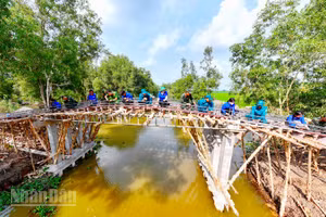 Cán bộ, chiến sĩ lực lượng vũ trang xã Hòn Đất hỗ trợ người dân xây dựng cầu dịp Tết quân-dân mừng Chôl Chnăm Thmây năm 2026.