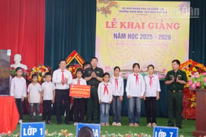 Đại tá Đào Quốc Thạo, Phó Bí thư Đảng ủy, Chỉ huy trưởng Bộ đội Biên phòng Lạng Sơn (đứng giữa) trao các phần hỗ trợ cho 10 em học sinh tại Trường Mầm non, Tiểu học và Trung học cơ sở Tam Gia, xã Khuất Xá, tỉnh Lạng Sơn.