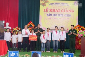 Đại tá Đào Quốc Thạo, Phó Bí thư Đảng ủy, Chỉ huy trưởng Bộ đội Biên phòng Lạng Sơn (đứng giữa) trao các phần hỗ trợ cho 10 em học sinh tại Trường Mầm non, Tiểu học và Trung học cơ sở Tam Gia, xã Khuất Xá, tỉnh Lạng Sơn.