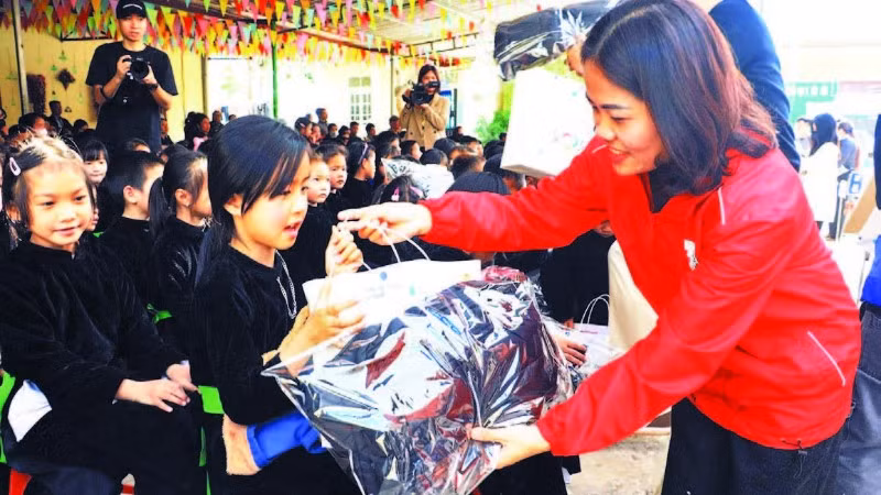 Lãnh đạo Hội Chữ thập đỏ trao quà cho các học sinh trên địa bàn. (Ảnh LƯƠNG THẢO)