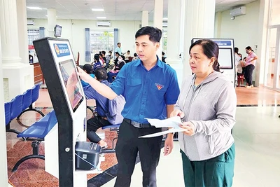 Cán bộ Trung tâm Phục vụ hành chính công phường Rạch Giá hướng dẫn người dân lựa chọn dịch vụ qua bảng điện tử.