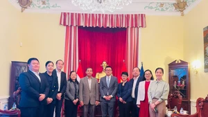 Đại sứ Vũ Lê Thái Hoàng và Đại sứ Khampheng Douangthongla cùng các thành viên Đại sứ quán hai nước chụp ảnh lưu niệm.