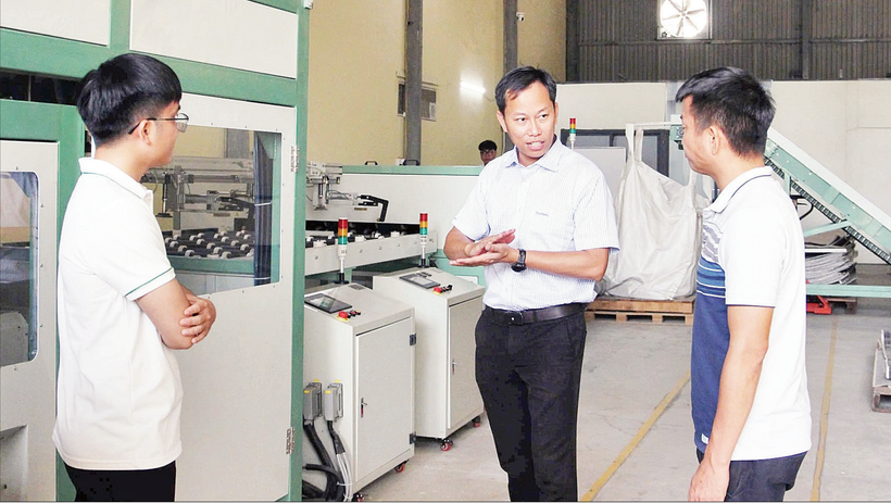 Tiến sĩ Đỗ Thế Cần (giữa) cùng cộng sự bên cạnh dây chuyền xử lý pin mặt trời.