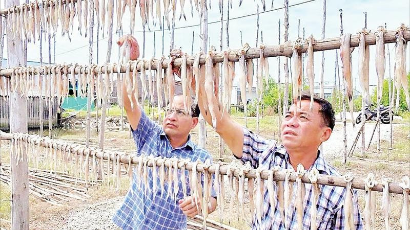 Chủ một cơ sở sản xuất kiểm tra chất lượng sản phẩm.