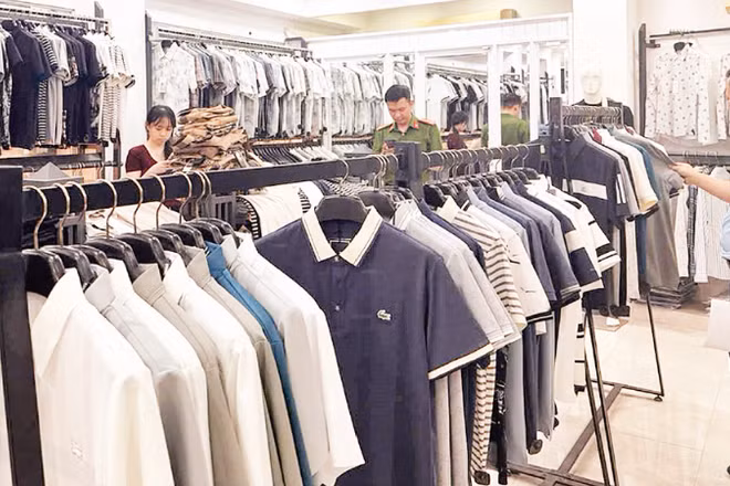 Lực lượng chức năng kiểm tra cửa hàng thời trang kinh doanh các sản phẩm giả mạo thương hiệu quốc tế tại phường Tây Tựu, thành phố Hà Nội. (Ảnh: TUẤN NGỌC)