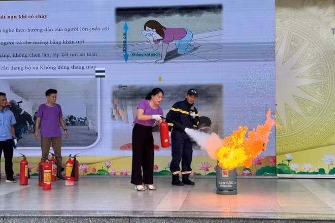 Giáo viên và học sinh Trường trung học cơ sở Trần Duy Hưng, phường Yên Hòa, Hà Nội. thực hành sử dụng các loại bình cứu hỏa phù hợp khống chế các điểm cháy, đám cháy nhỏ. (Ảnh: LÊ ĐỨC-PHẠM TRUNG)