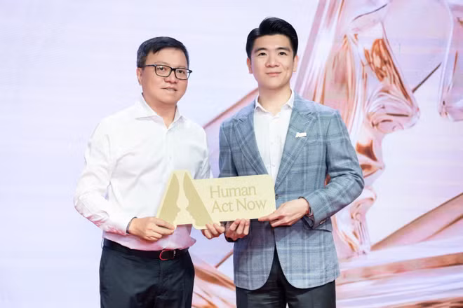 Đồng chí Lê Quốc Minh, Ủy viên Trung ương Đảng, Tổng Biên tập Báo Nhân Dân, Phó Trưởng ban Tuyên giáo Trung ương, Chủ tịch Hội Nhà báo Việt Nam, Trưởng Ban tổ chức Human Act Prize 2026, trao cúp cho ông Đỗ Quang Vinh, Phó Chủ tịch Hội đồng quản trị kiêm Phó Tổng Giám đốc SHB, tại chương trình. (Ảnh: ANH TRƯỜNG)