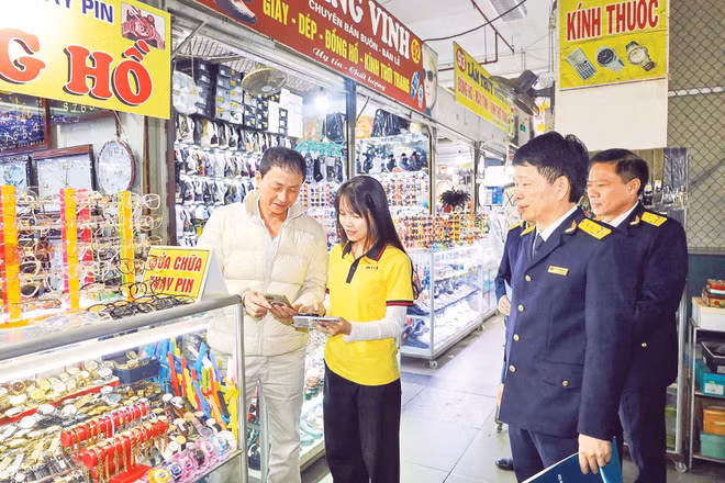 Cơ quan thuế cơ sở 16 Thành phố Hà Nội hướng dẫn hộ kinh doanh thực hiện thủ tục về thuế bằng phương thức điện tử. (Ảnh: HÀ ANH)