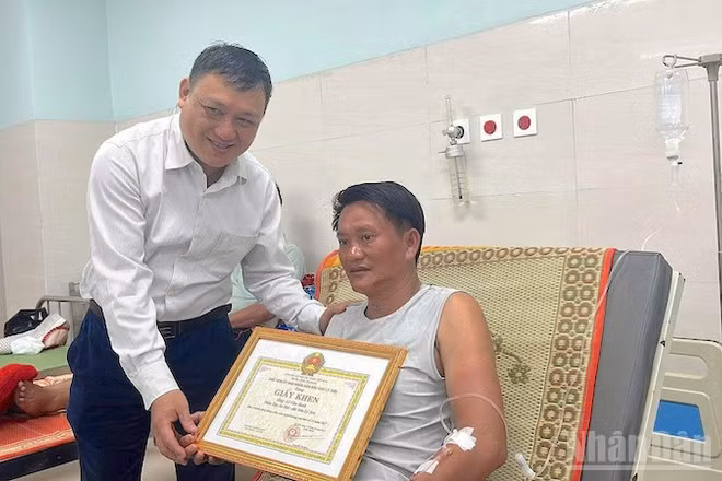Chủ tịch Ủy ban nhân dân đặc khu Lý Sơn trao bằng khen cho ông Lê Văn Sanh.