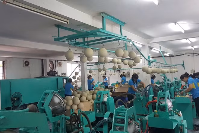 Người lao động với dây chuyền sản xuất bóng thi đấu tại Công ty cổ phần Động Lực. (Ảnh: HOÀI THU)