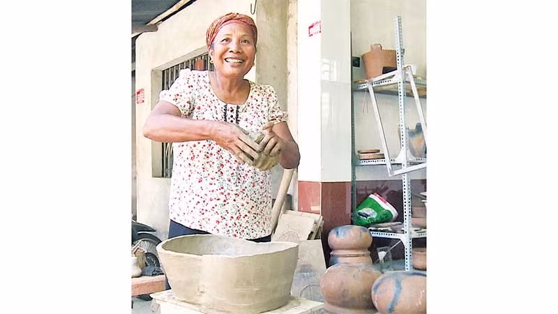 Nghệ nhân Neáng Sana bên những sản phẩm gốm thủ công.