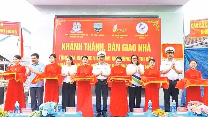 Các đại biểu và gia đình Mẹ Việt Nam Anh hùng Bùi Thị Bẻn cắt băng khánh thành nhà (Ảnh CTV)