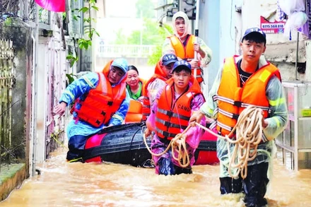 Lực lượng Cảnh sát phòng cháy, chữa cháy và cứu nạn, cứu hộ hỗ trợ người dân phường Thục Phán (Cao Bằng) di dời đến nơi an toàn. (Ảnh: TRÍ CAO)