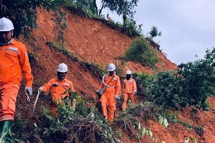 Công nhân Công ty Điện lực Điện Biên đi bộ vượt núi khắc phục sự cố do lũ quét.