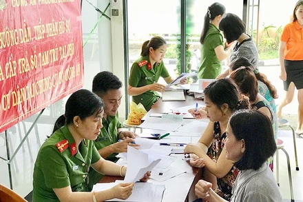 Công an Thành phố Hồ Chí Minh hướng dẫn người dân làm thủ tục đăng ký cư trú. (Ảnh: NHÂN SƠN)