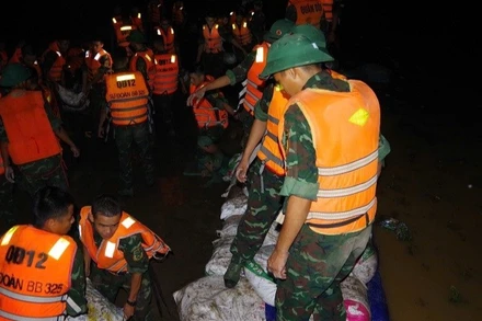 Bộ đội Sư đoàn 325 tích cực gia cố đê sông Cầu thuộc địa bàn xã Tam Giang. (Ảnh: QUANG ĐẠO)