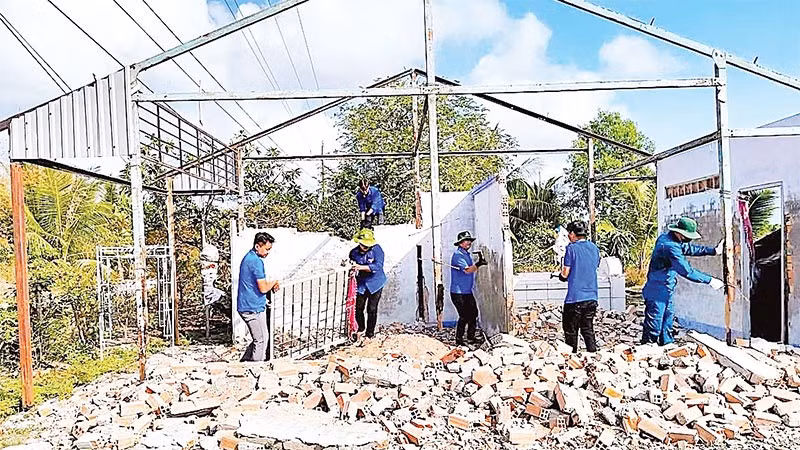 Đoàn viên, thanh niên Cà Mau quyên góp ngày công lao động giúp hộ dân tiết kiệm chi phí cất nhà mới. (Ảnh HỮU TÙNG)