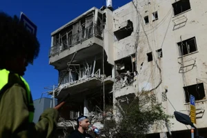 Lực lượng an ninh Israel và các nhân viên cứu hộ làm việc tại hiện trường vụ tấn công tên lửa từ Iran vào Tel Aviv, Israel, ngày 24/3/2026. (Ảnh: Xinhua)