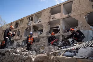 Lực lượng cứu hộ tại hiện trường vụ tấn công tên lửa của Iran xuống khu vực ở thành phố Dimona, Israel ngày 22/3/2026. (Ảnh: THX/TTXVN)