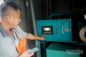 Ông Trần Xuân Phong vận hành máy phát điện từ khí biogas. (Ảnh: TRUNG HƯNG)